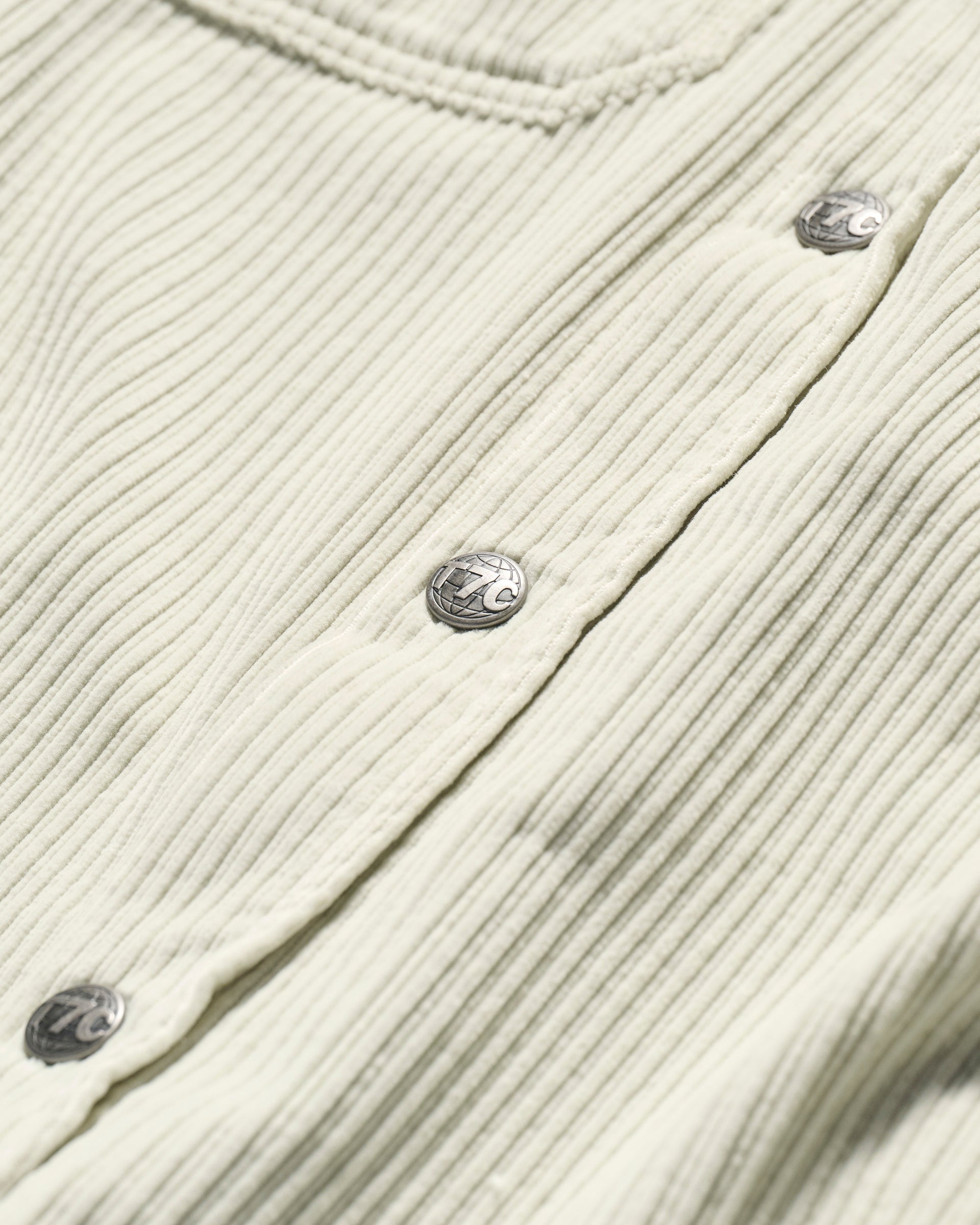 Close-up of The Aiden Overshirt in Cream by T7C, featuring ribbed Japanese corduroy fabric and silver snap buttons. The detailed texture and stitched seam highlight the relaxed style of this premium overshirt.