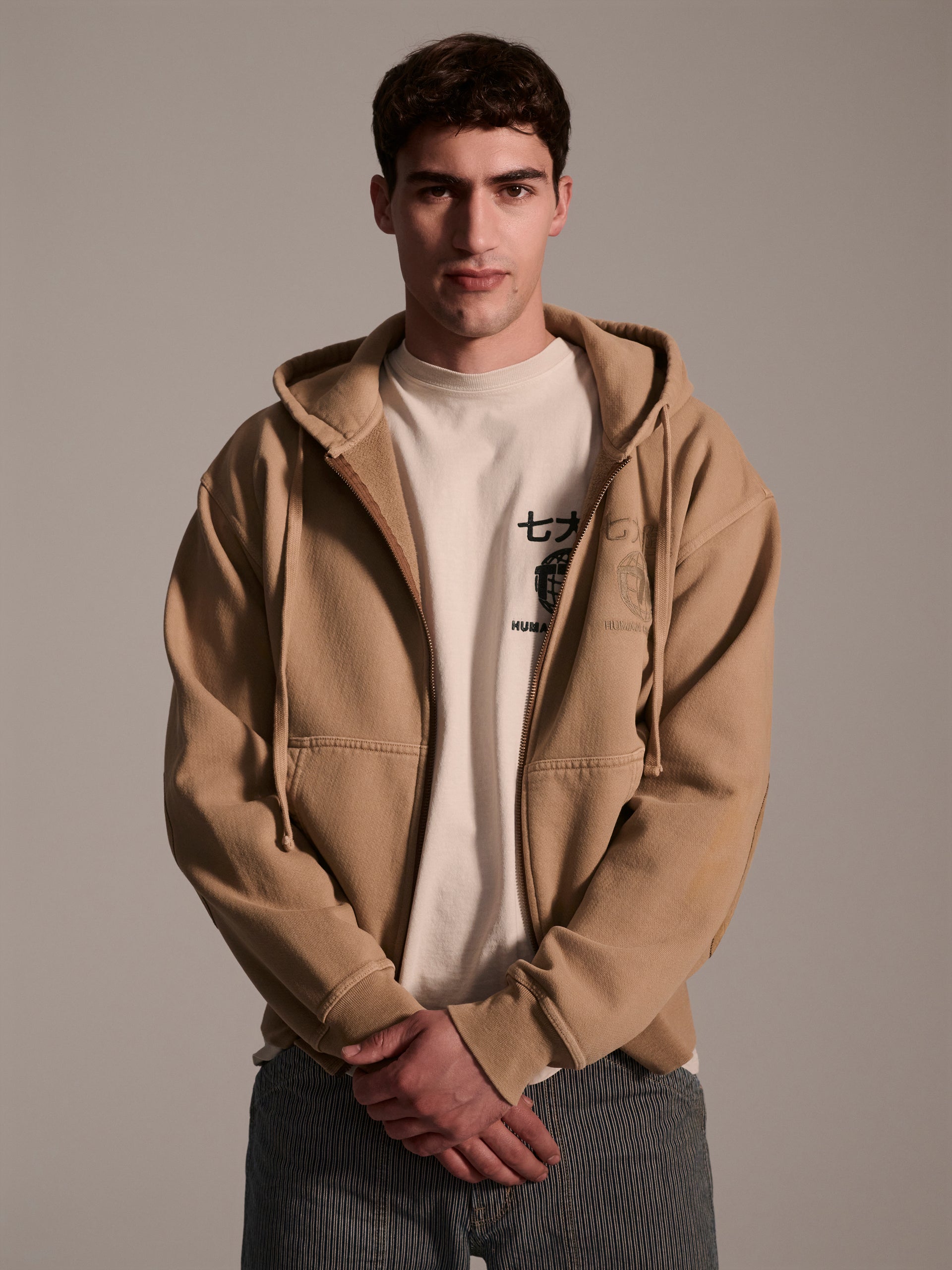 A male model wearing a tan hoodie