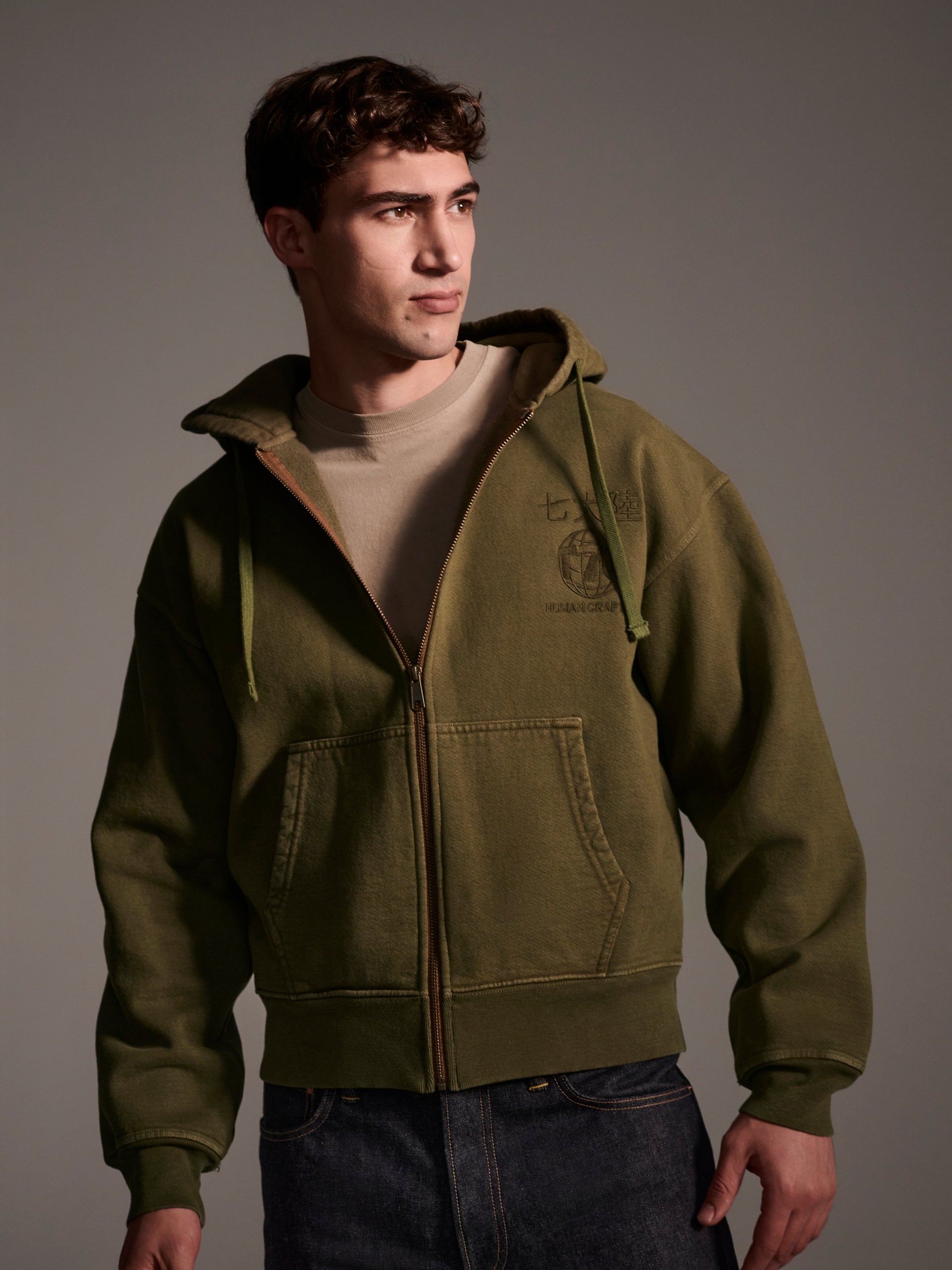 A male model in an olive zip-up hoodie