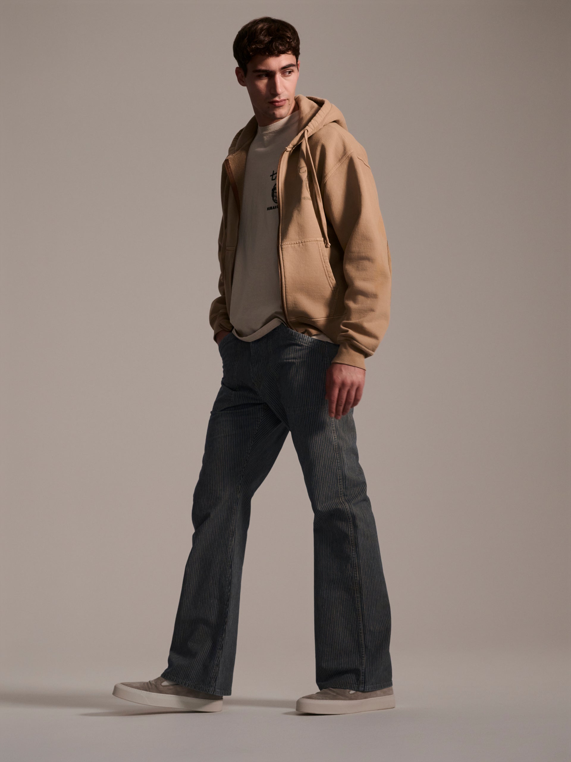 A profile image of a male model wearing blue and white railroad stripe flare pants