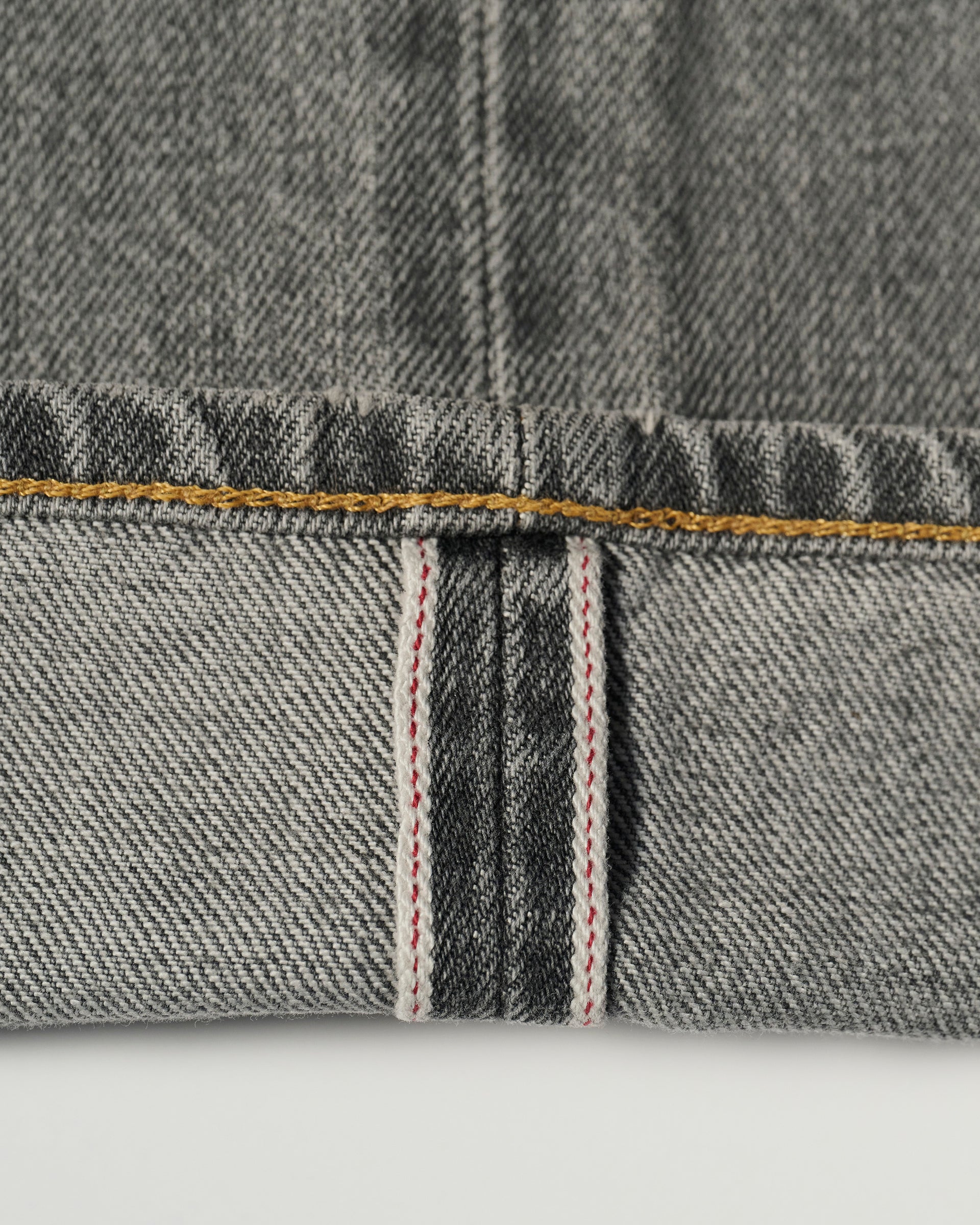 Close-up of the cuff of The Jack Jean in Cloud by T7C, highlighting the white and red selvedge edge, visible gold seam, and textured weave crafted from premium organic Turkish cotton.