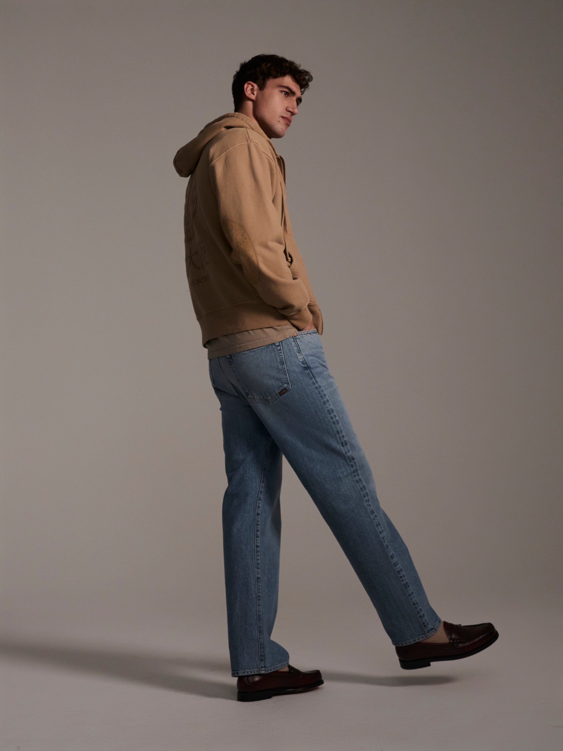 A profile image of a male model wearing light blue relaxed fit denim jeans