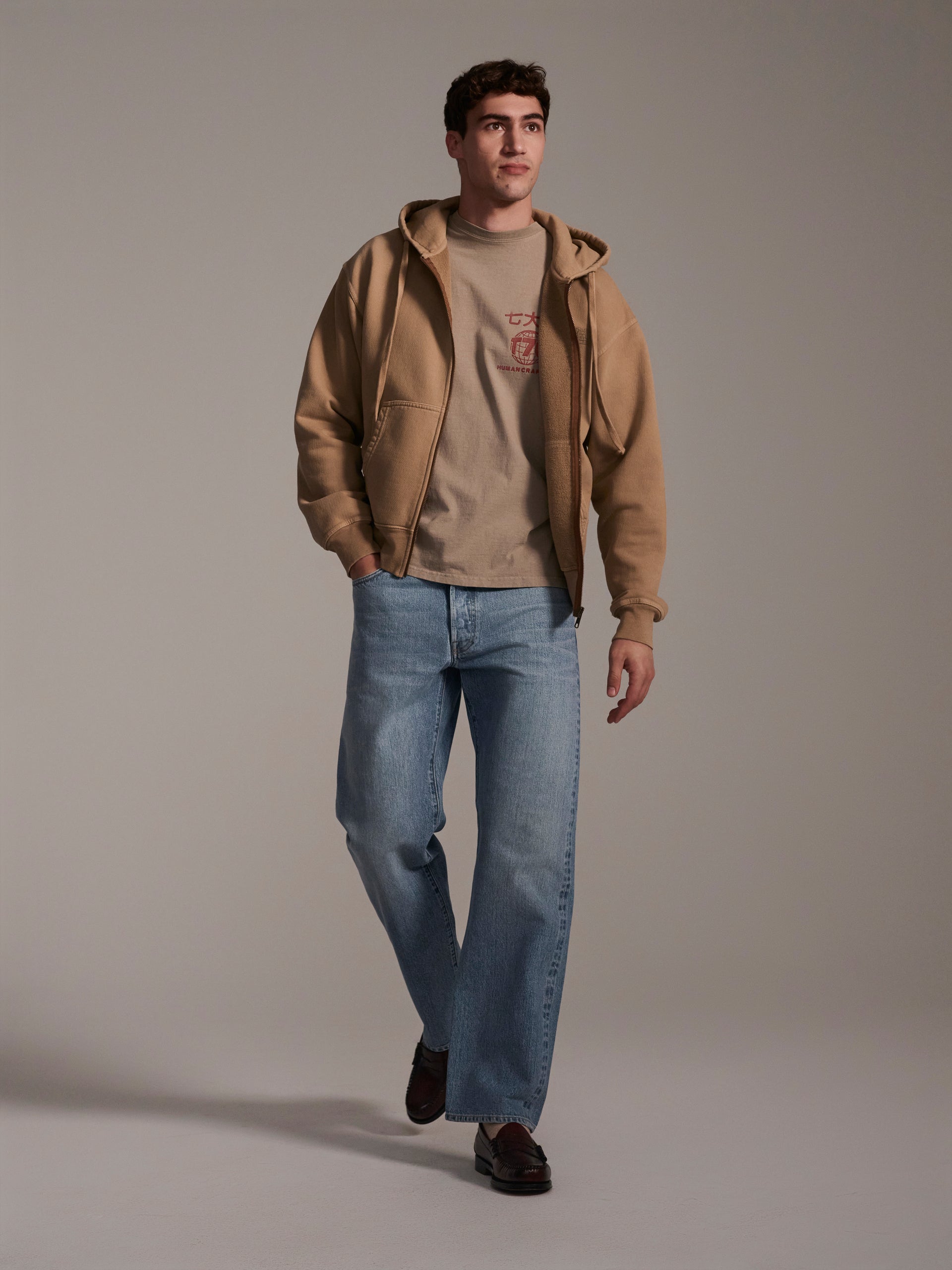 A frontal image of a male model wearing light blue relaxed fit denim jeans