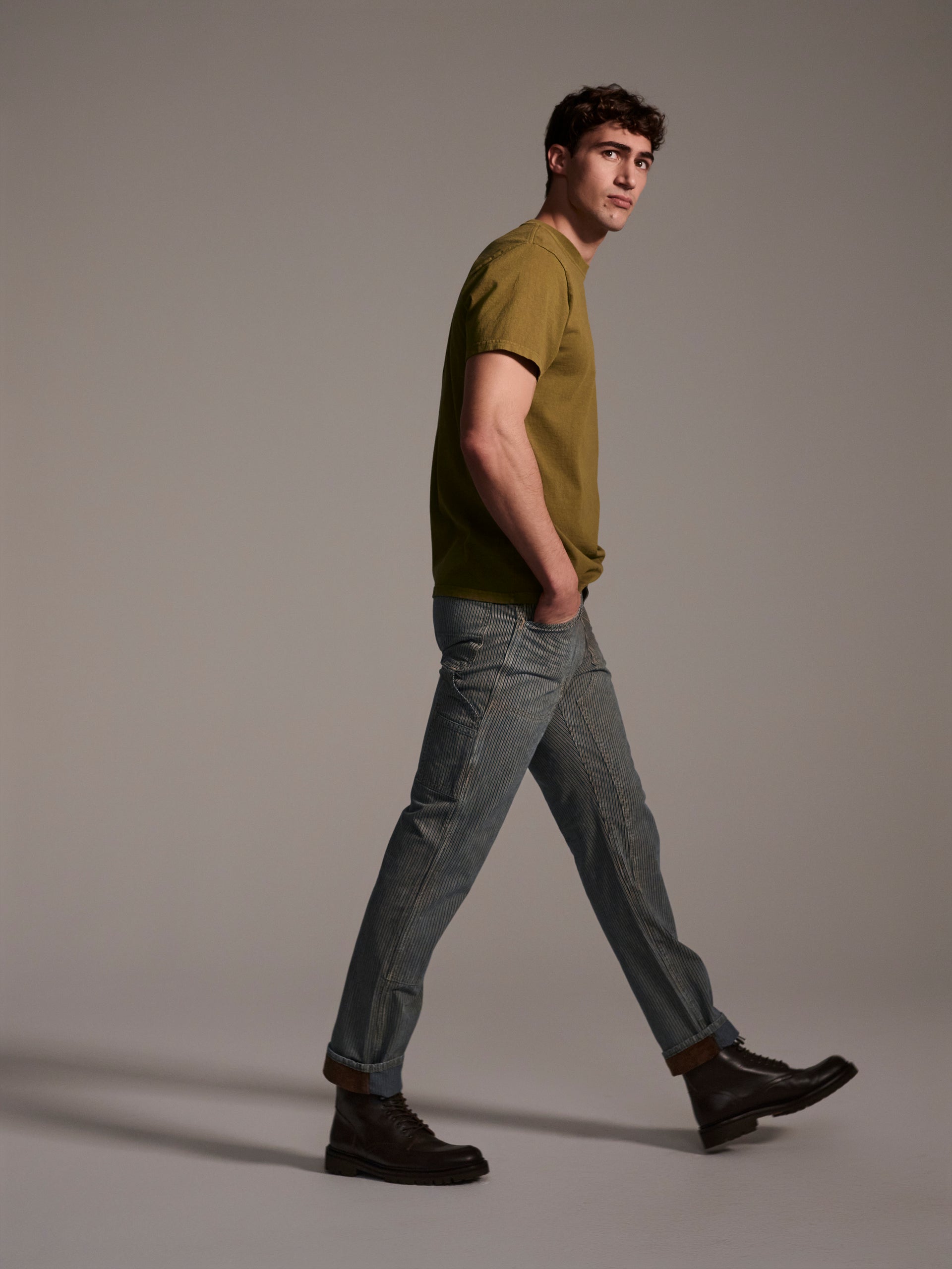 A profile image of a male model wearing a blue and white railroad stripe carpenter pant