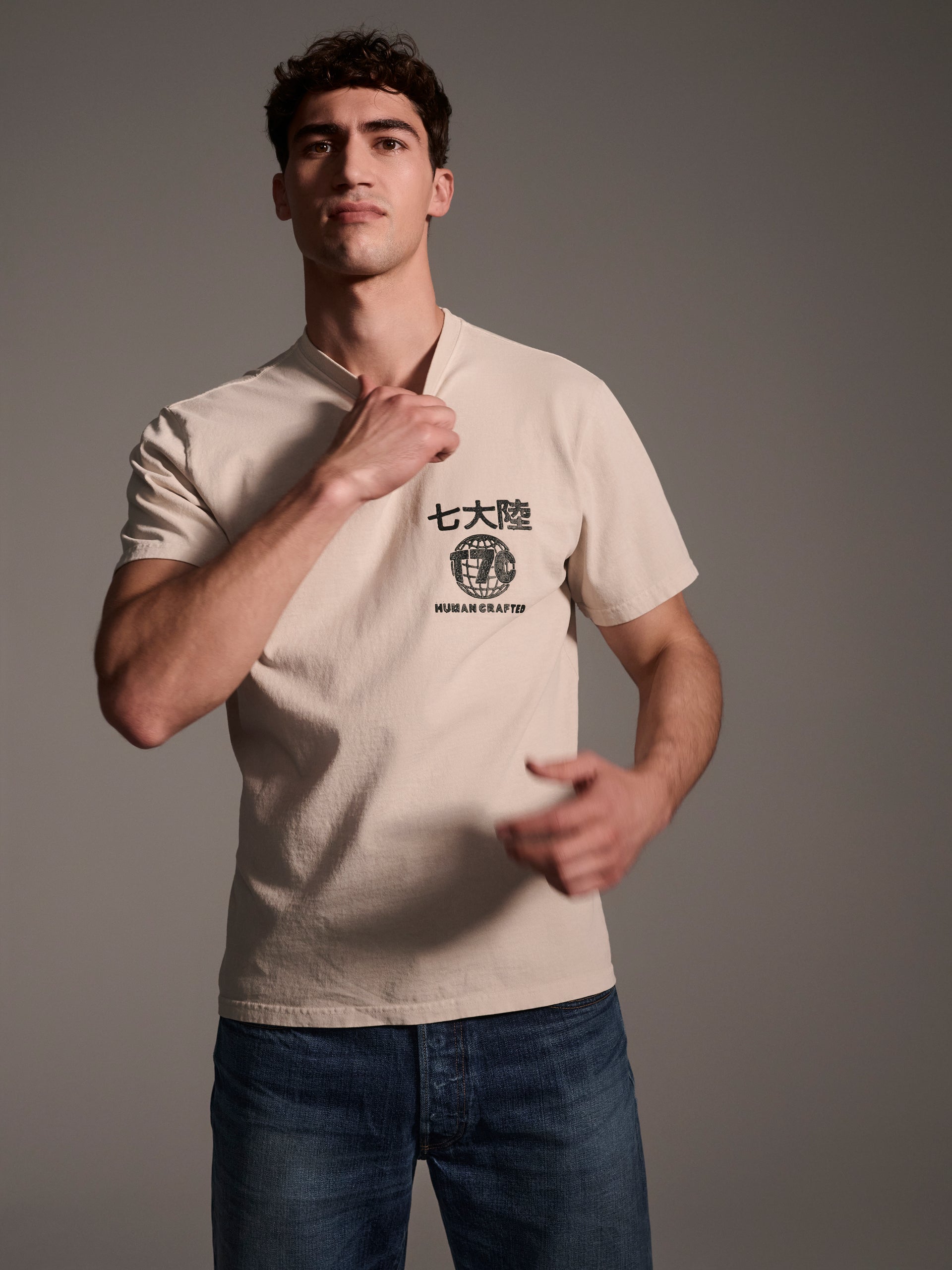 A front image of a male model wearing an off-white t-shirt with a logo detail