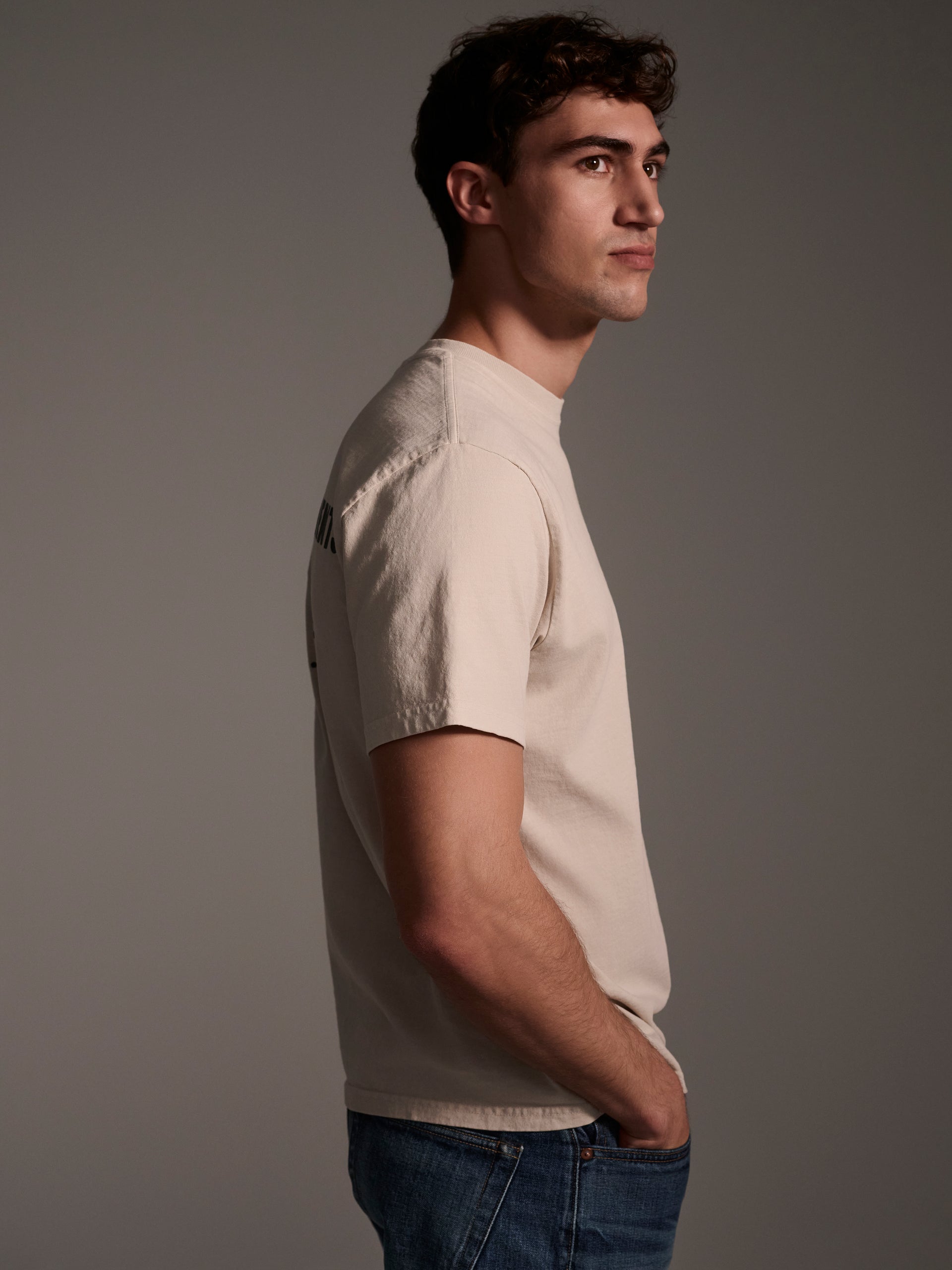 A profile image of a male model wearing an off-white t-shirt with a logo detail